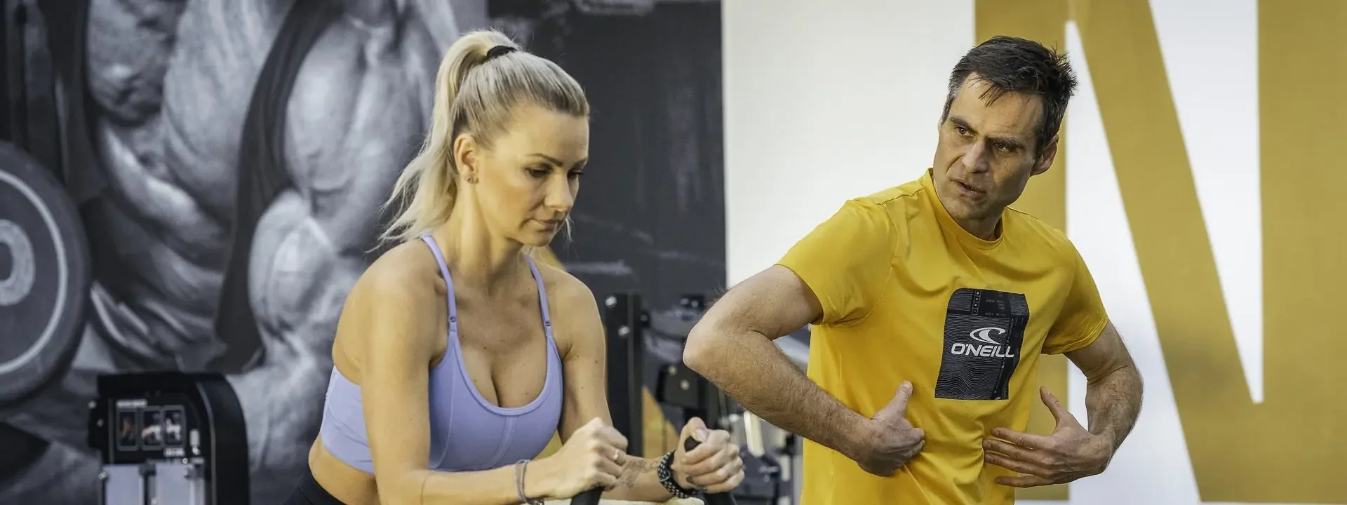Michal Kroupa vede klientku při cvičení na stroji